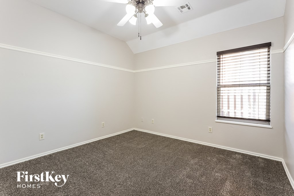 a room with carpet and a window and a ceiling fan