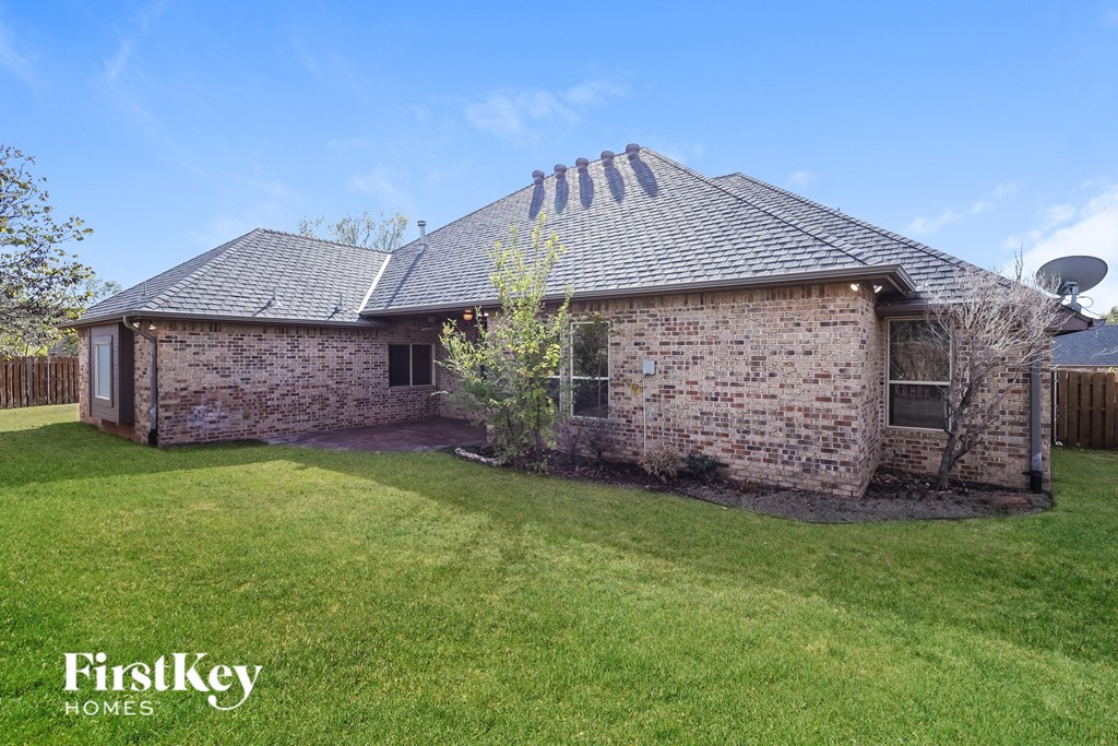 a small brick house with a grassy yard and a garden