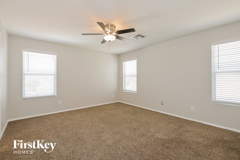 a living room with carpet and a ceiling fan