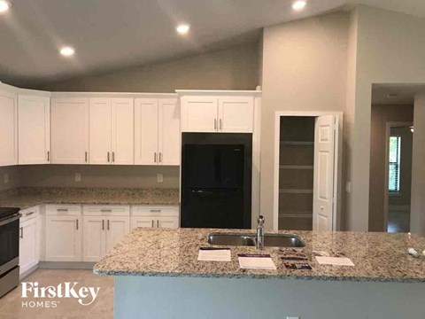 A kitchen with a granite countertop and white cabinets.