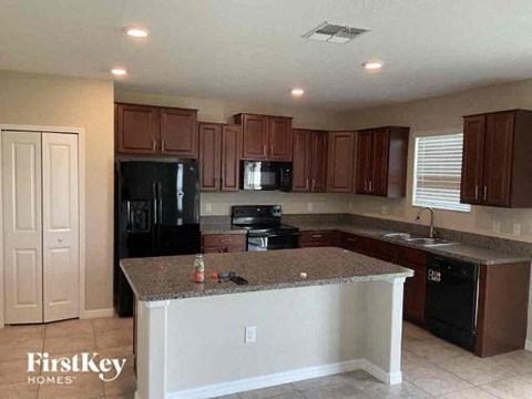 A kitchen with brown cabinets and a granite countertop.