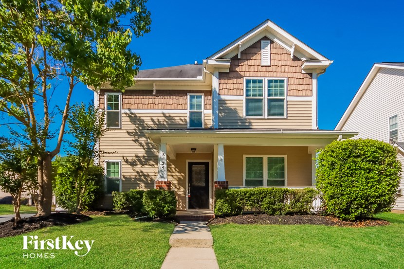 a house with a lawn and a sidewalk in front of it