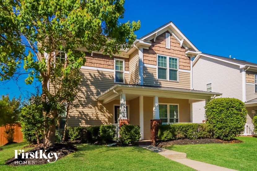 a house with a lawn and a tree in front of it