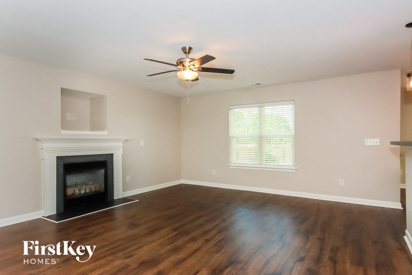 a living room with a fireplace and a ceiling fan