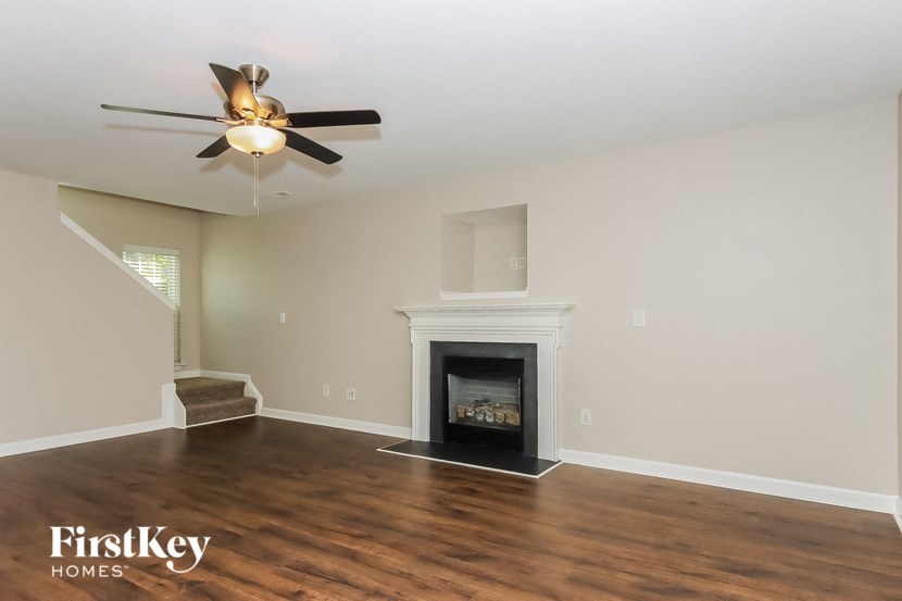 a living room with a fireplace and a ceiling fan
