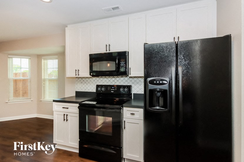 a kitchen with black appliances and white cabinets