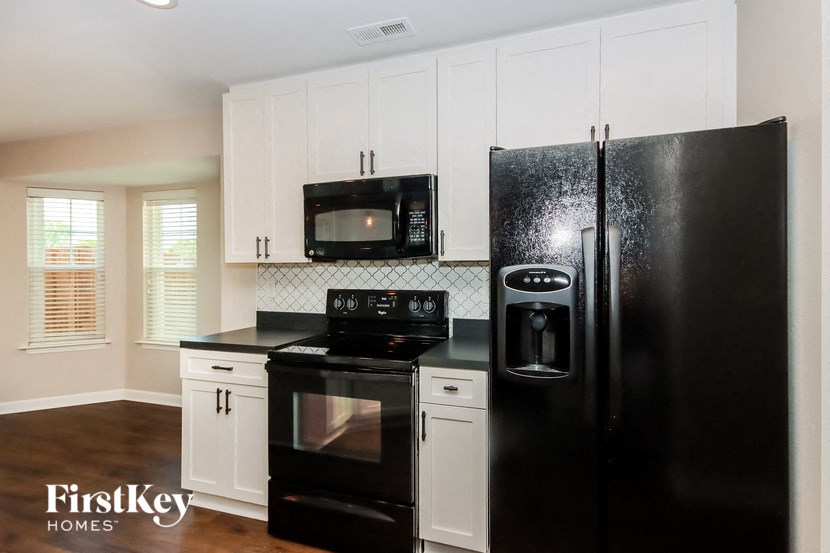 a kitchen with black appliances and white cabinets