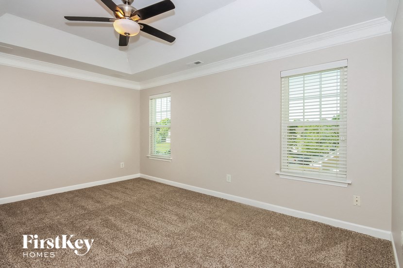 a empty room with a ceiling fan and window