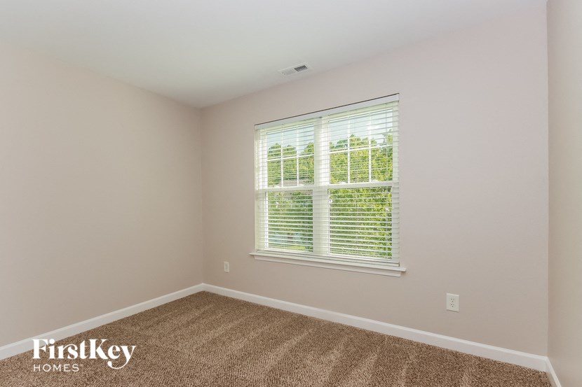 the second bedroom with carpet and a large window