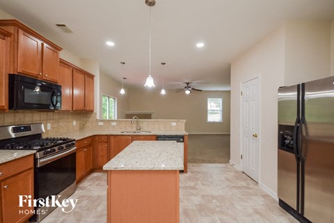 A kitchen with wooden cabinets and a granite countertop.
