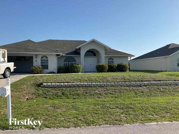 A house with a white garage door and a stone wall in front.