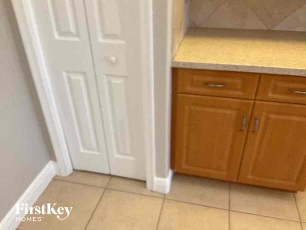 A kitchen area with wooden cabinets and a white door.