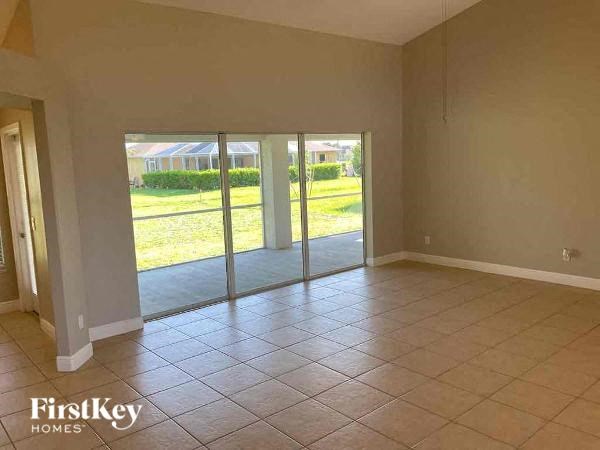 A room with tiled flooring and sliding glass doors leading to a green outdoor area.