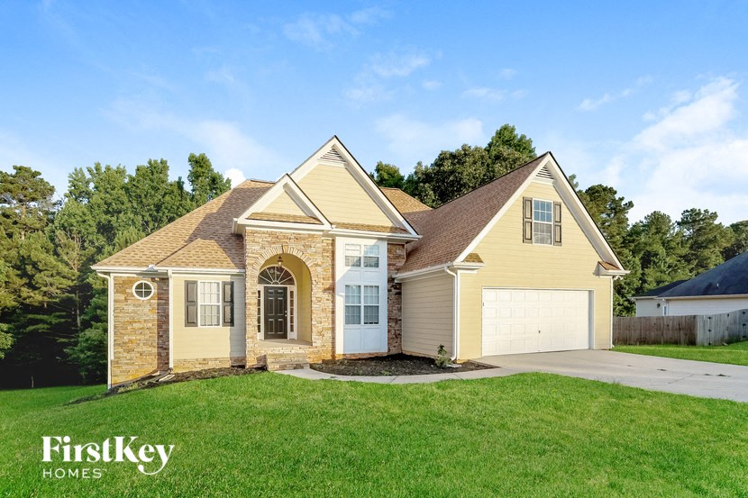 A house with a brown roof and a garage door is for sale.