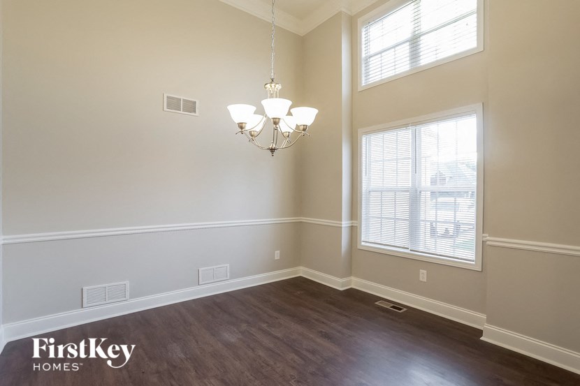 A well-lit room with a chandelier and a window.