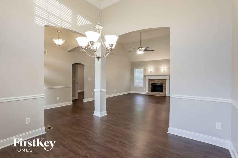 A large, empty room with wood floors and a fireplace.