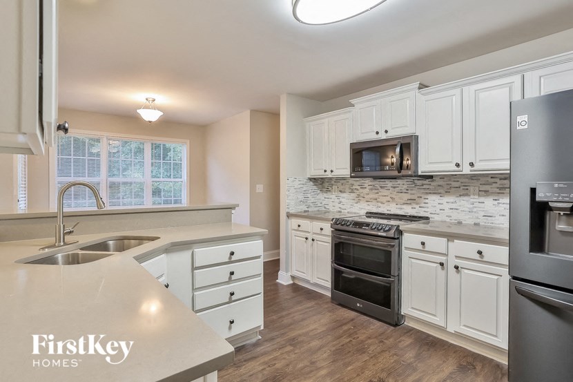 A kitchen with a stove top oven and a refrigerator.