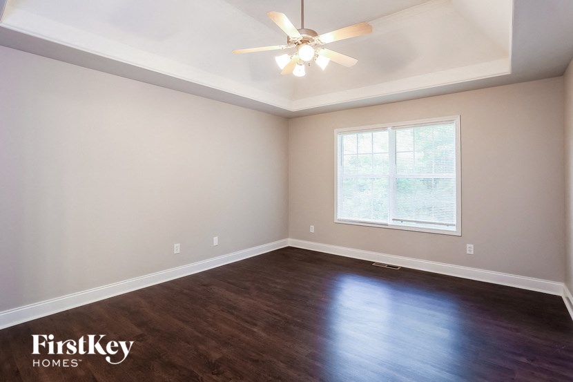 A room with a ceiling fan and a window.