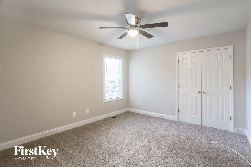 A room with a ceiling fan and a door.