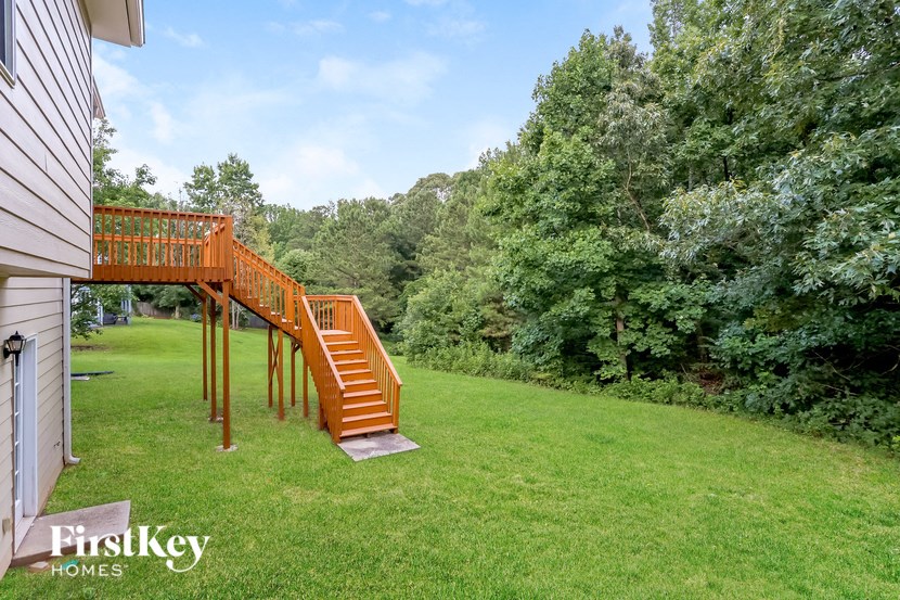 A wooden staircase leads up to a lush green area.