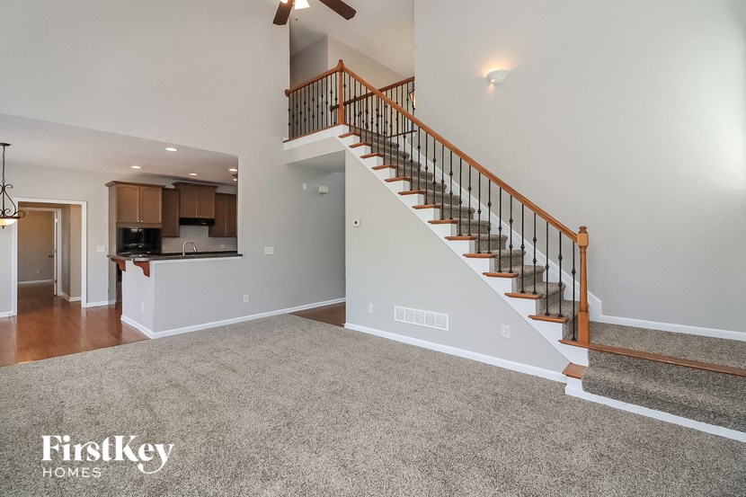 A spacious living room with a staircase leading to the upper floor.