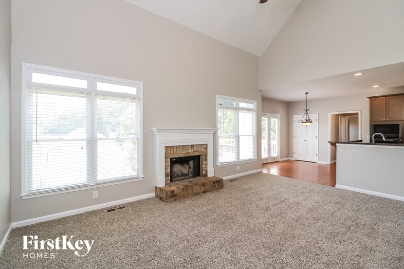 A spacious living room with a fireplace and large windows.