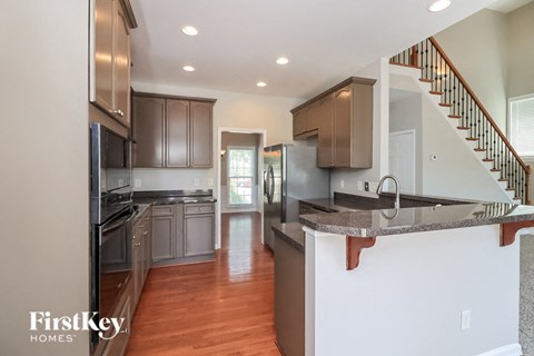 A kitchen with a stainless steel refrigerator and wooden cabinets.