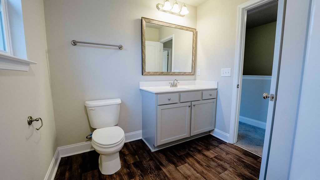a bathroom with a toilet sink and mirror
