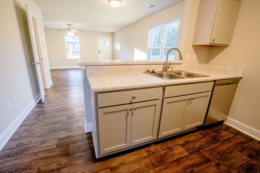 an empty kitchen with white cabinets and a sink