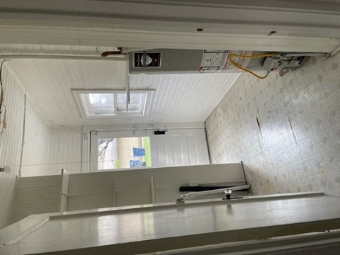 A white ceiling with a skylight and a white wall with a window.