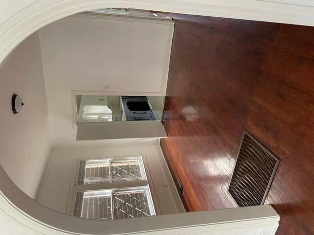 A white refrigerator with a freezer drawer and a small freezer compartment is in a room with wooden flooring.