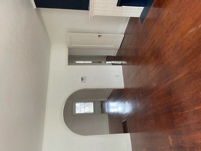 A white wall with a window and a brown wooden wall.