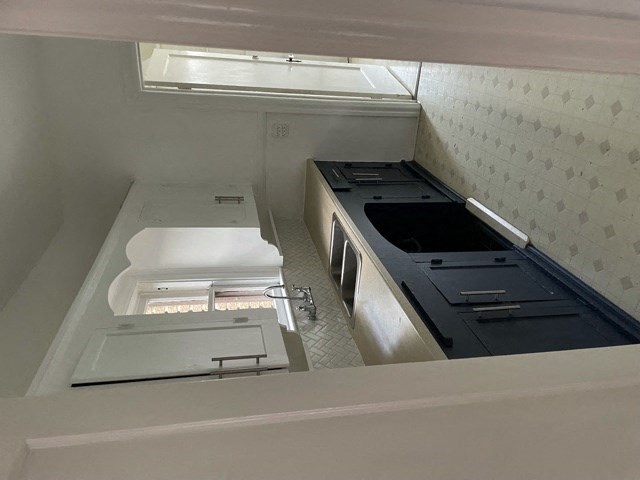 A white kitchen with a dishwasher and sink.