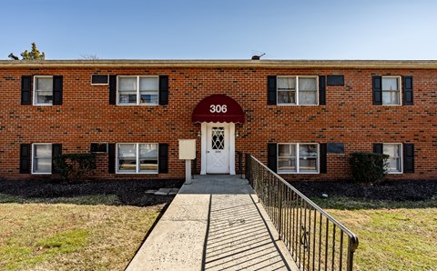 the front of a brick building with a white door