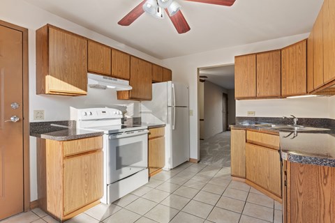 A kitchen with wooden cabinets and a white refrigerator.