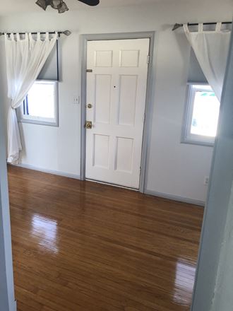 an empty room with a wooden floor and a white door