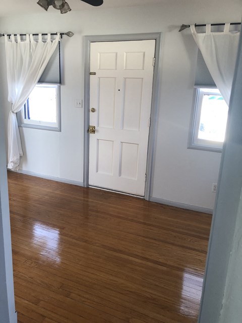 an empty room with a wooden floor and a white door