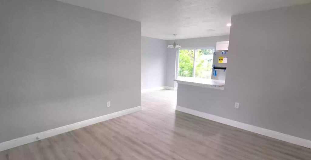 an empty living room with a hard wood floor