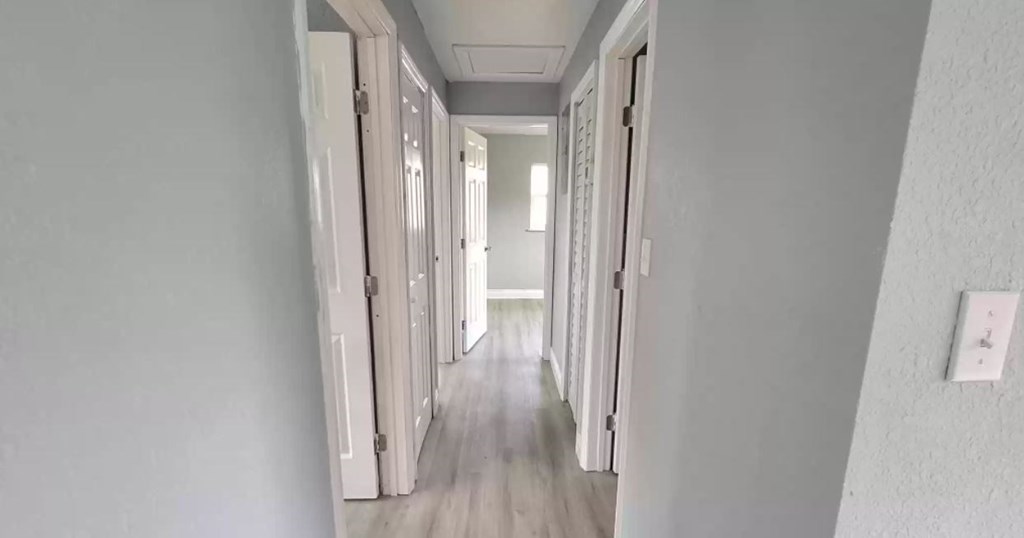 a hallway with a wood floor and white walls