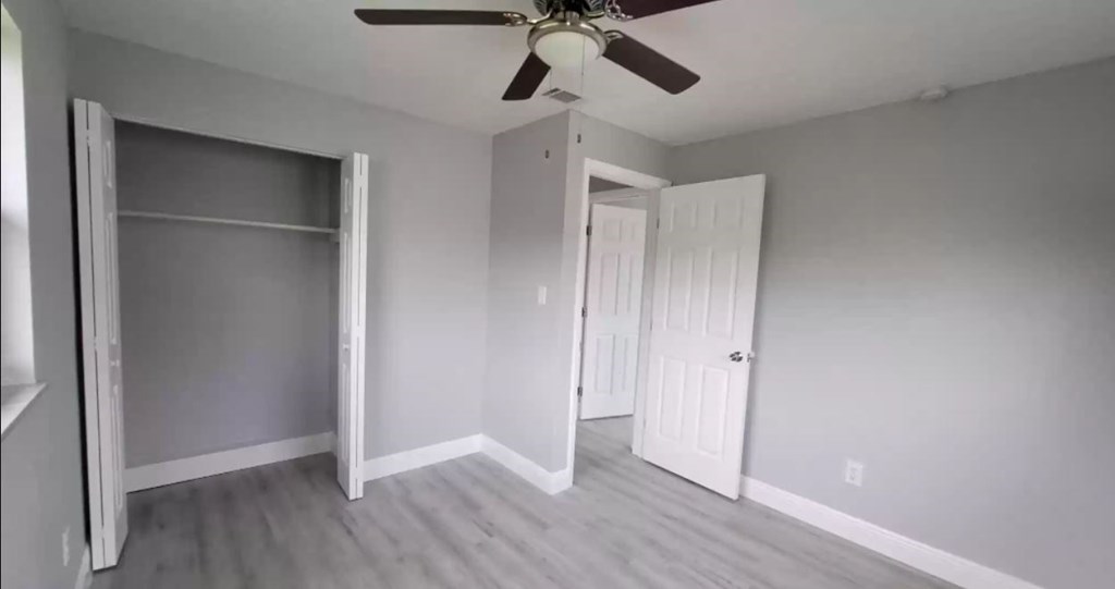 an empty room with a ceiling fan and a closet