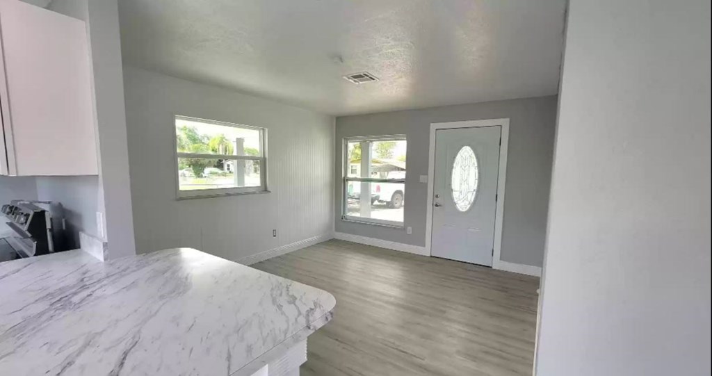 the living room and dining room of a house with a marble counter top