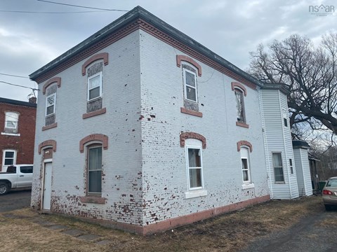 an old white brick building with white paint and red bricks