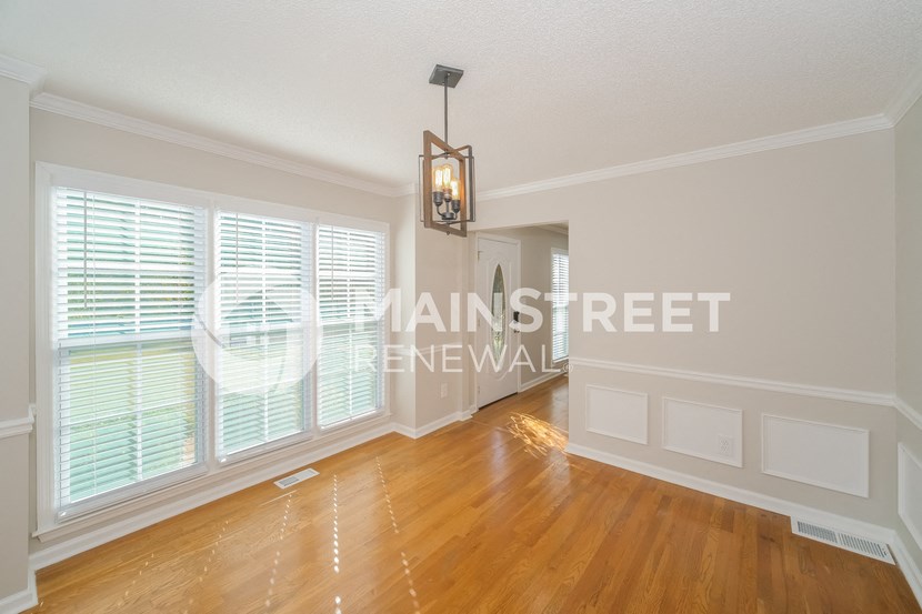 a living room with a large window and a hard wood floor