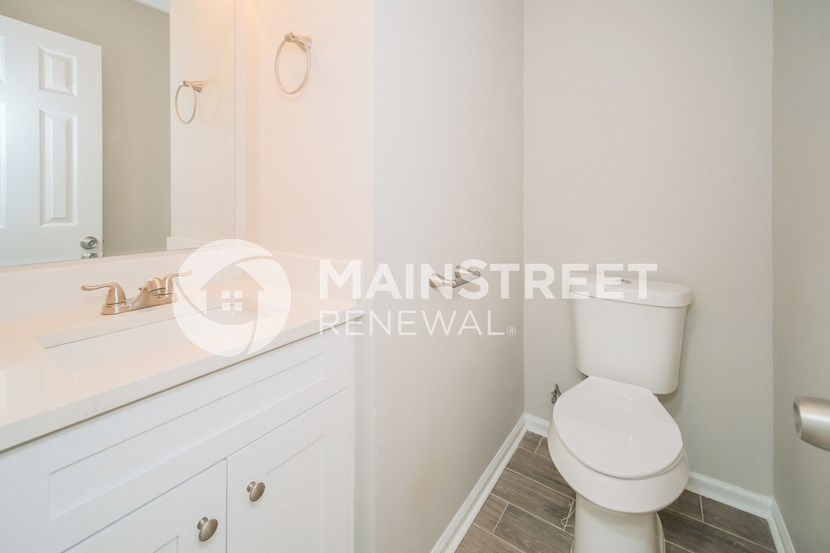bathroom with white cabinets and a toilet