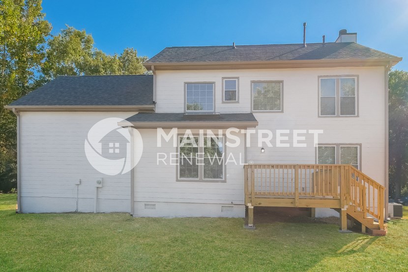 a small white house with a porch and a deck