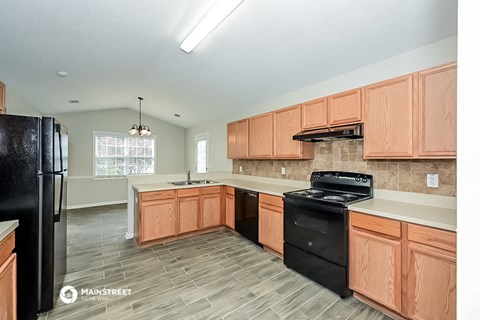 a large kitchen with wooden cabinets and black appliances