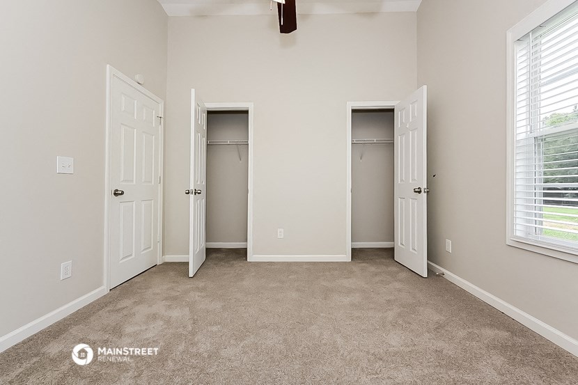 an empty room with two closets and two doors