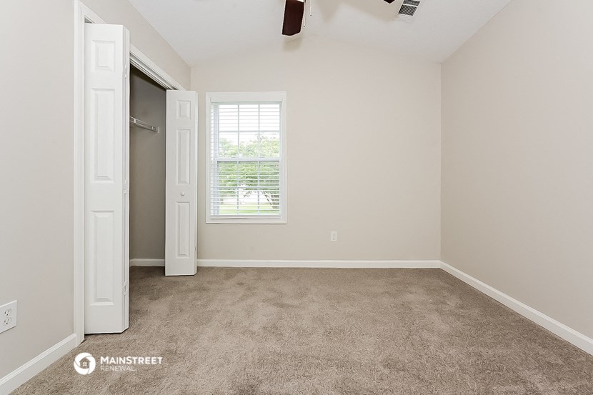 an empty room with a closet and a window