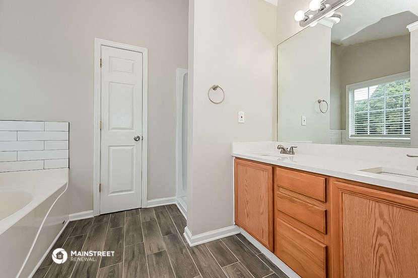 a bathroom with a tub and a sink and a mirror