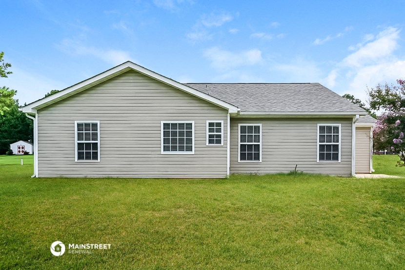 the front of a white house with a grassy yard